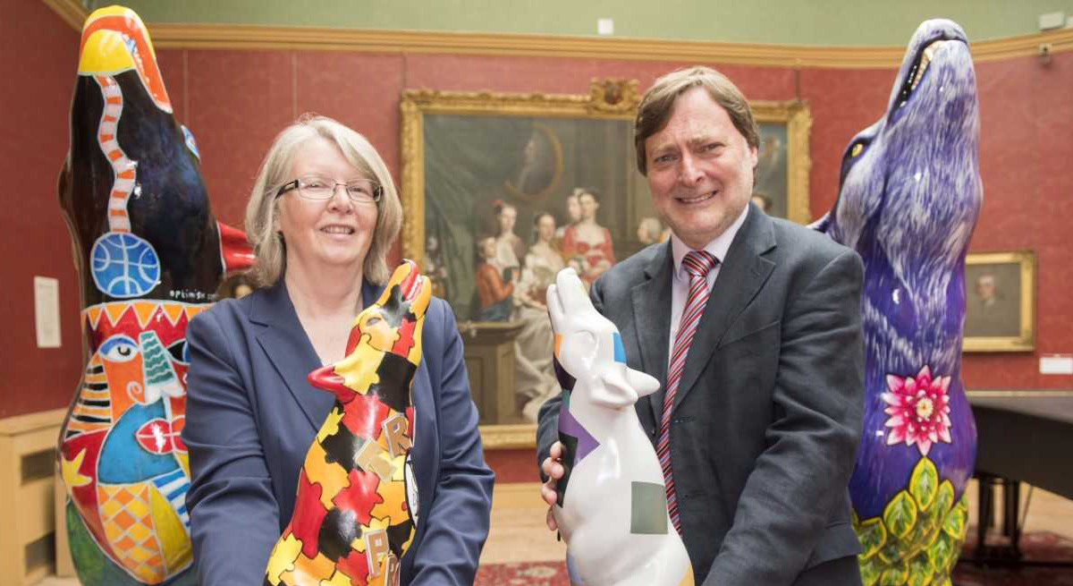 Cllr Claire Darke, Wolves in Wolves artist, and Cllr John Reynolds with two of the mini wolves